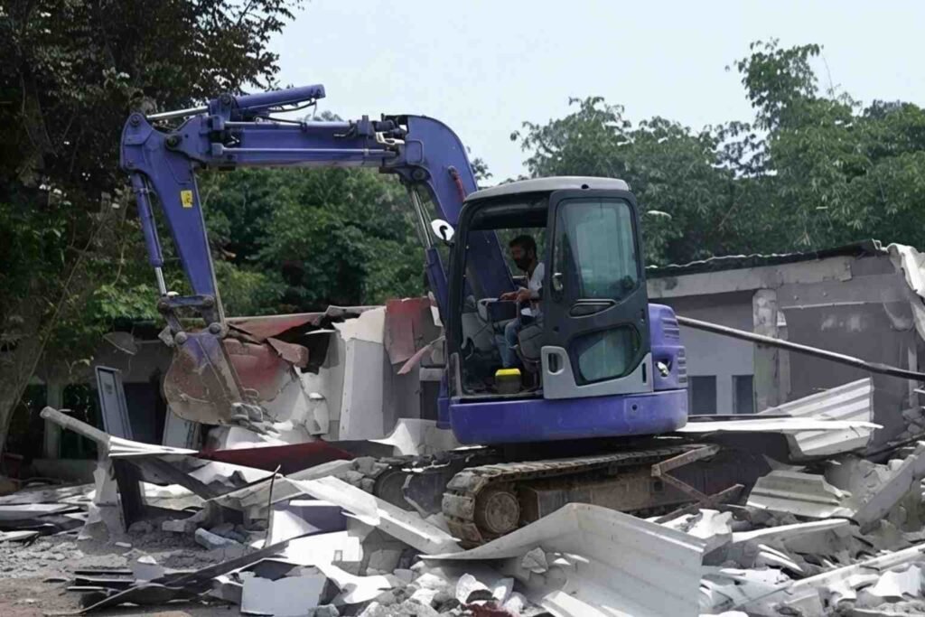 Ekskavator merobohkan bangunan di lingkungan Lapas Kelas IIA Cibinong, dengan puing-puing berserakan di sekitarnya.