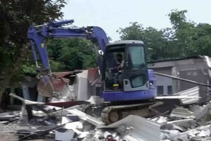 Ekskavator merobohkan bangunan di lingkungan Lapas Kelas IIA Cibinong, dengan puing-puing berserakan di sekitarnya.